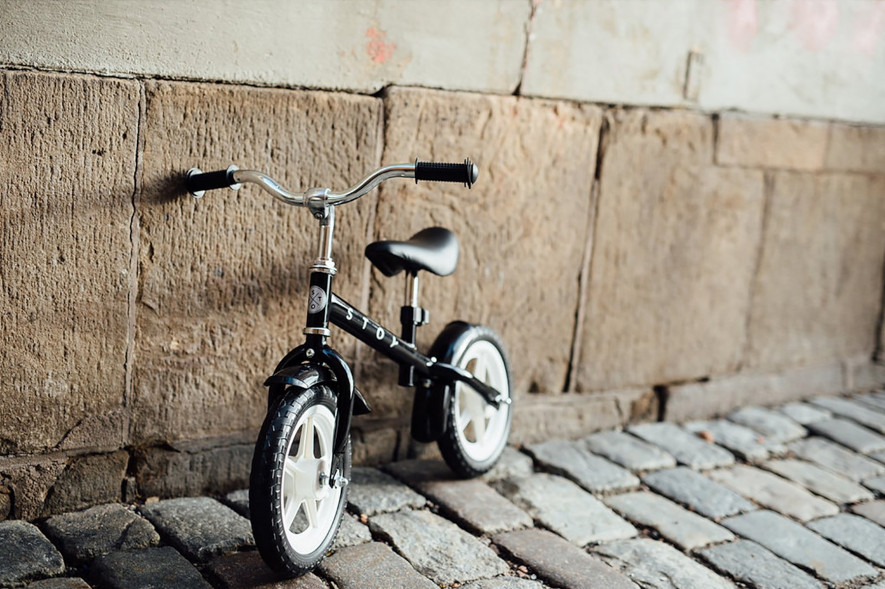 Svart Stoy Springcykel, cykel lutandes mot vägg